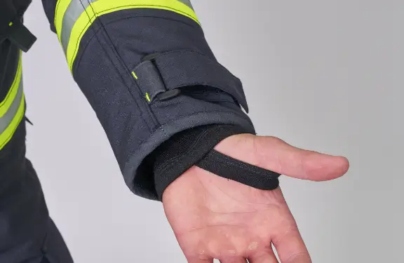 Hook and loop fastener for sleeve adjustment, a moisture barrier on the inner side and a fireretardant cuff with a thumb hole.